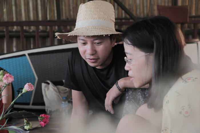 Anh Đinh Thắng (người sáng lập chợ phiên) đang trò chuyện với chủ một gian hàng.