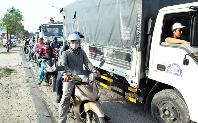 Do tránh những “bẫy” trên đường nên các xe tải chạy sát vào làn xe hai bánh và người đi xe máy chỉ còn một phần đường chưa tới 1m để lưu thông.