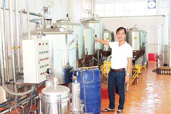 Anh Đặng Tường Khanh bên hệ thống máy làm rượu từ sản phẩm phụ của cây ca cao (cơm trái, nước…).