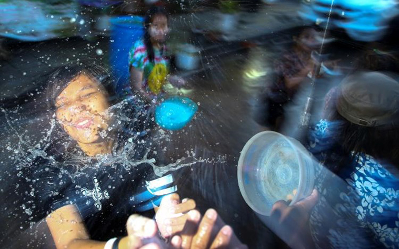 Cô gái vui vẻ hứng trọn cả chậu nước trong lễ hội Songkran truyền thống.
