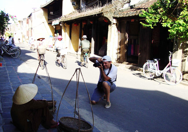 Một du khách chụp ảnh về cụ bà thân thiện bên gánh hàng rong phố Hội (Ảnh: Hoàng Tuấn)