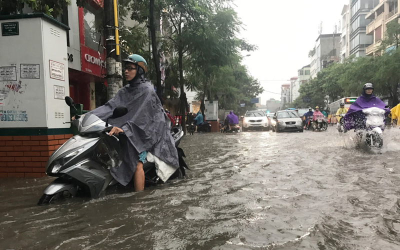 Trận mưa có cường độ lớn ngay lập tức gây xáo trộn giao thông do đúng lúc giờ người dân trên đường đi làm. Ảnh: Tiến Tuấn.
