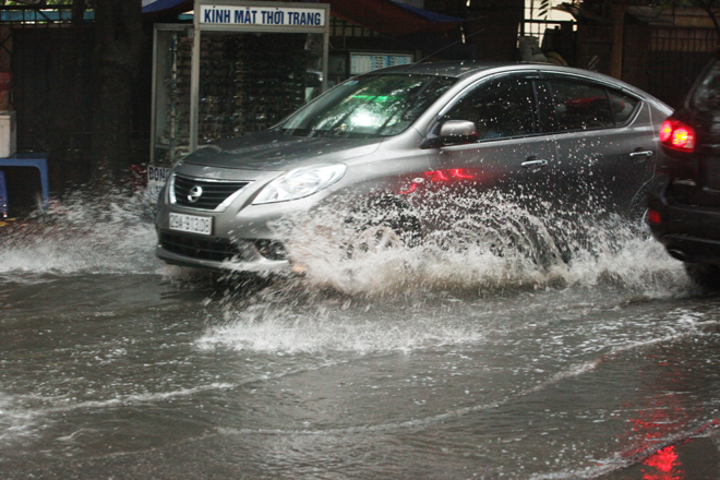 Cơn mưa khiến nhiều tuyến đường ngập nhẹ, nhưng người dân vẫn vui vẻ rẽ nước về nhà