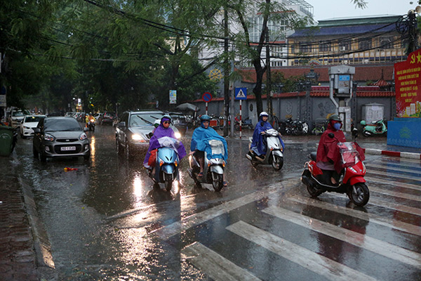 Người dân ở khu vực trung tâm Hà Nội vui mừng tận hưởng không khí mát mẻ do cơn mưa mang lại
