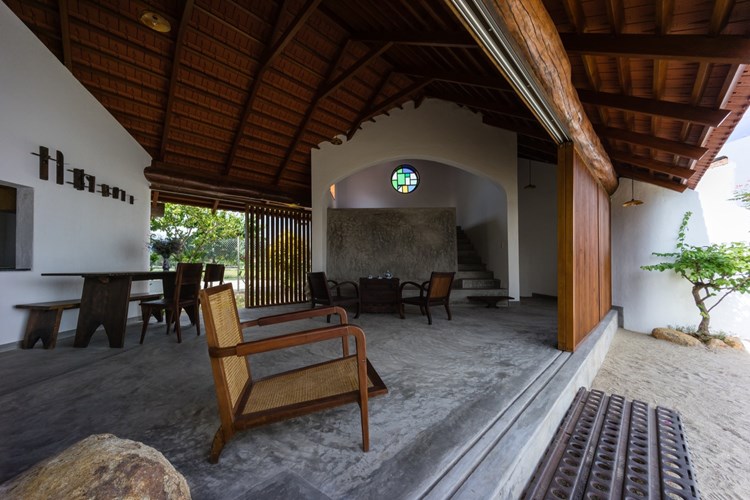 Phòng khách thoáng đãng, mộc mạc với bộ bàn ghế gỗ truyền thống.