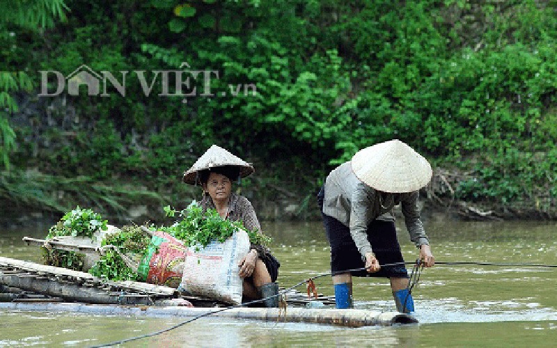 Người dân bản Pom Sinh hàng ngày phải vượt dòng Nậm Hua hung dữ bằng chiếc mảng mỏng manh. Ảnh: Vinh Duy