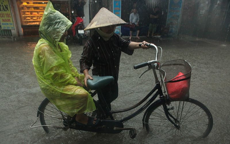 Để đảm bảo an toàn cho các em nhỏ, các em ngồi trên xe người lớn dắt qua vùng nước sâu