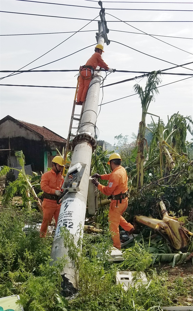 Công nhân điện lực dựng lại cột điện bị đổ