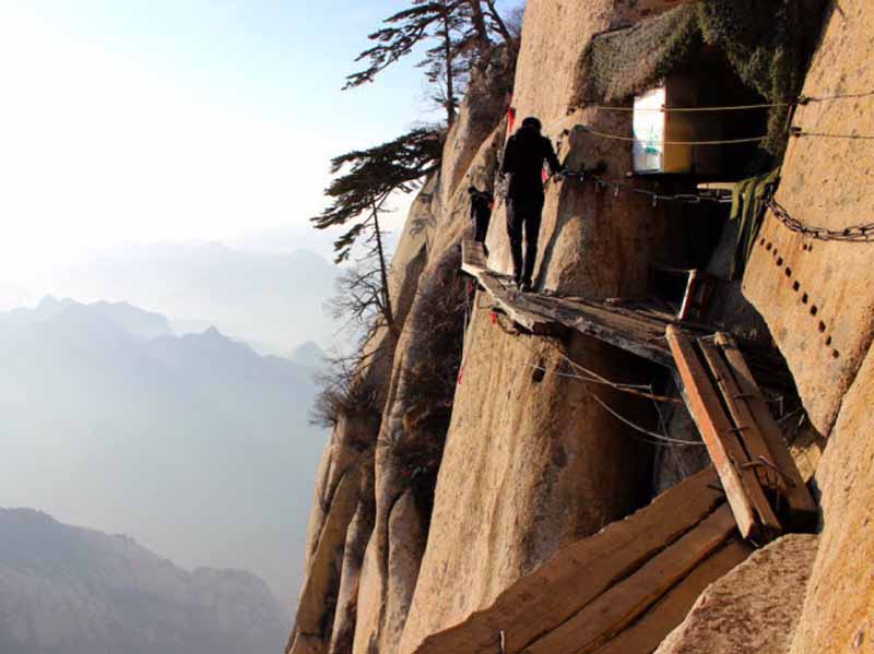 Núi Hóa Sơn, Trung Quốc: Lối đi dẫn tới đỉnh ngọn núi Hóa Sơn chỉ là những tấm gỗ mục trên vách đá dựng đứng cách mặt đất hàng trăm mét. Được coi là tuyến đi bộ nguy hiểm nhất thế giới, khoảng 100 người đã tử vong mỗi năm khi chinh phục ngọn núi này.