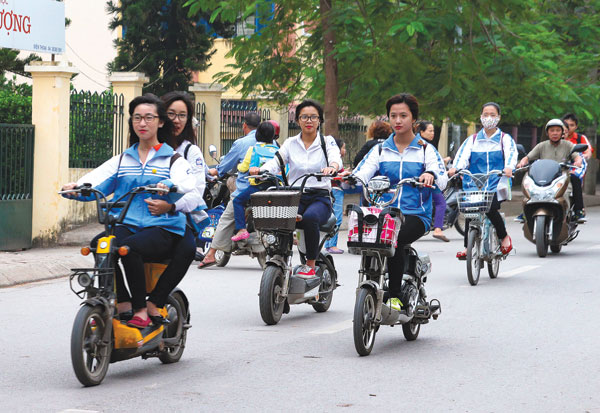 Luật Giao thông đường bộ chưa có quy định về độ tuổi được phép điều khiển xe đạp, xe máy điện (Chụp trên phố Phú Gia, đường An Dương Vương, Hà Nội) - Ảnh: Khánh Linh