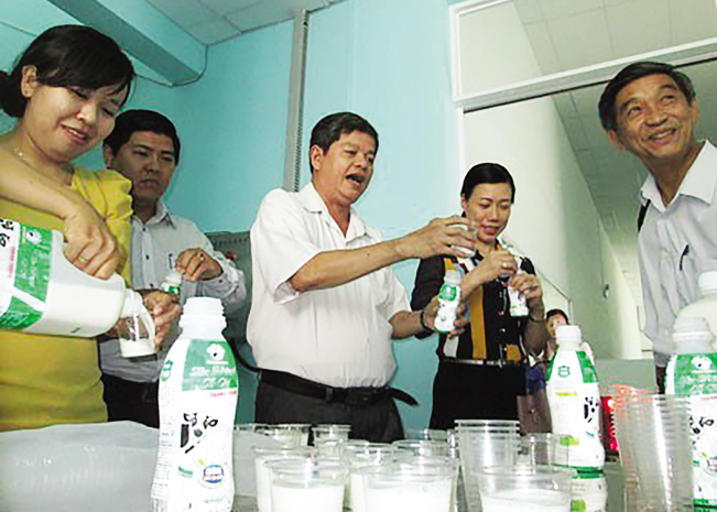 Ông Nguyễn Minh Khánh kiểm tra chất lượng các sản phẩm sữa của nhà máy.