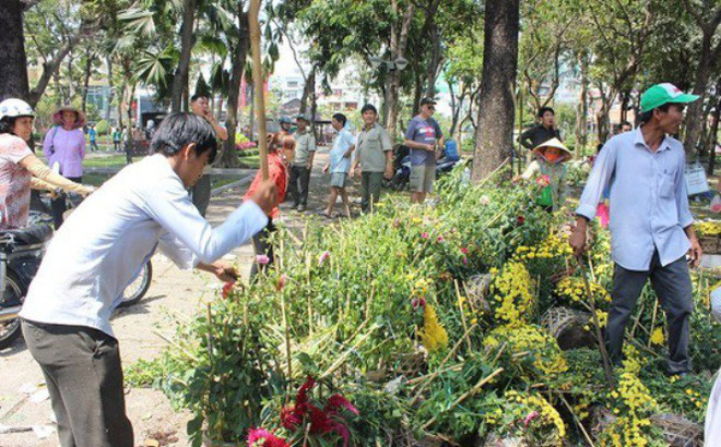 Tức giận vì không bán được, không để người khác có cơ hội hôi của, chủ bán hoa đã đập nát từng giỏ hoa vào dịp 30 Tết năm 2017. Ảnh: Người lao động.