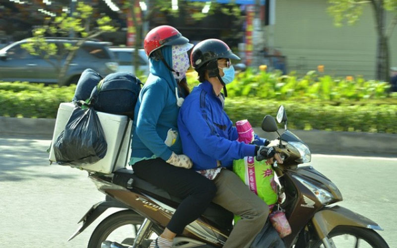  Hai vợ chồng di chuyển bằng xe máy cá nhân cùng nhiều đồ đạc.