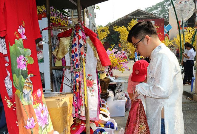 Nhiều bạn trẻ tỏ ra rất thích thú với gian hàng cho thuê áo dài khăn đóng để chụp hình ở phố ông đồ Sài Gòn. Ảnh: Phúc Anh.