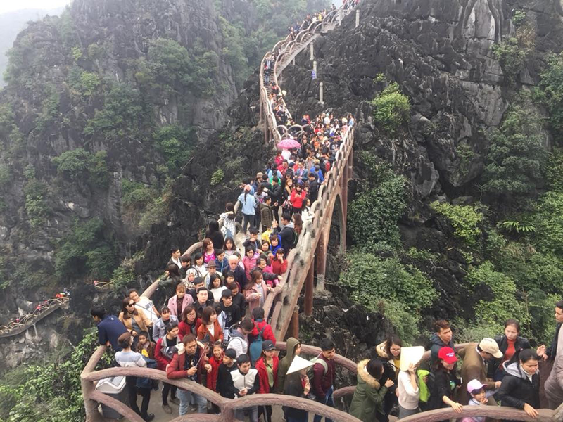 Cầu thang dẫn lên đỉnh núi ở Tràng An cổ là nơi vãn cảnh đẹp nên dù leo khá mệt, mất khoảng 30 phút đến một tiếng, nhiều người vẫn nhích từng bước giữa dòng người. Ảnh: Trần Quân.