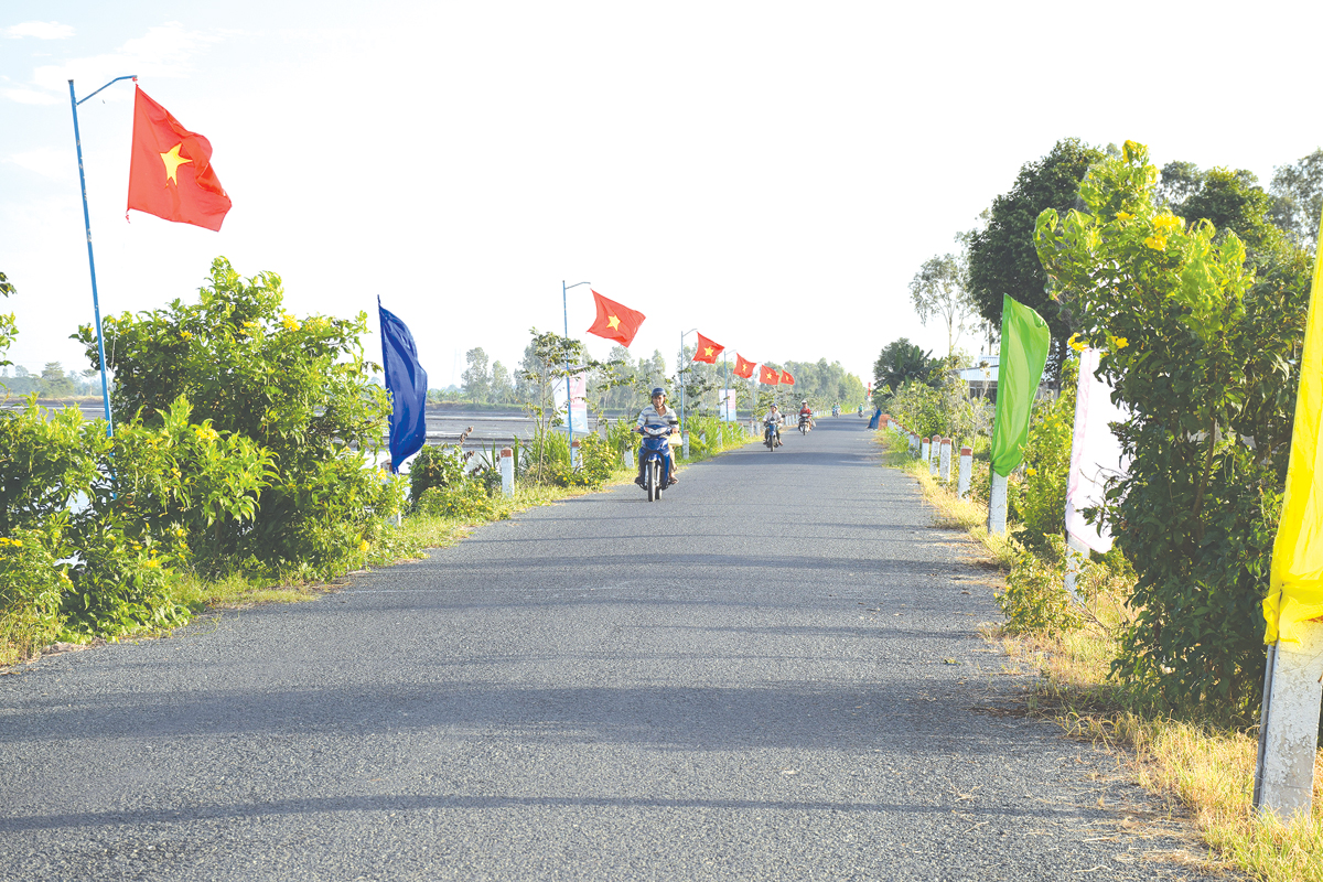 Đường giao thông phẳng phiu, thông thoáng, hoa trồng 2 bên đường là hình ảnh dễ dàng bắt gặp khi đến với các xã nông thôn mới. (Đoạn đường đi qua xã Vĩnh Bình, huyện Vĩnh Thạnh).