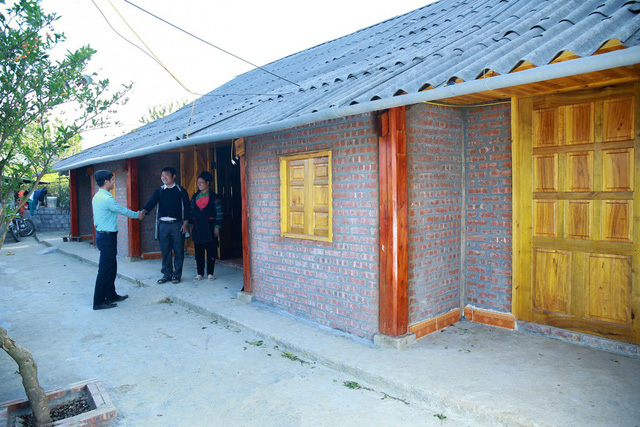 Vợ chồng anh chị Má A Câu và Vàng Thị Pang bên ngôi nhà gỗ thông mới dựng.