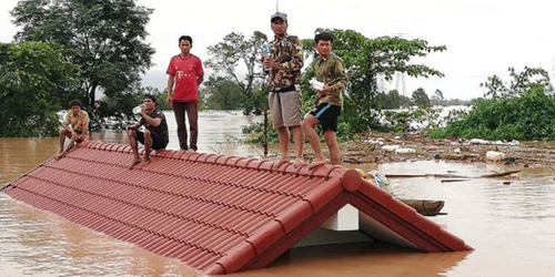 Người dân đứng trên nóc nhà chờ giải cứu khi nước lũ dâng cao do vỡ đập thủy điện. (Ảnh: Attapeu Today)