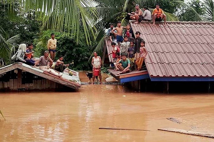 Người dân Lào bị mắc kẹt trên mái nhà khi nước lũ dâng cao do sự cố vỡ đập thủy điện Xe Pian-Xe Namnoy. Ảnh: EPA.