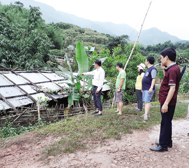 Cán bộ Phòng Lao động TB&XH huyện Mường Nhé hướng dẫn người dân phòng tránh mưa gió tốc mái nhà mùa mưa lũ.
