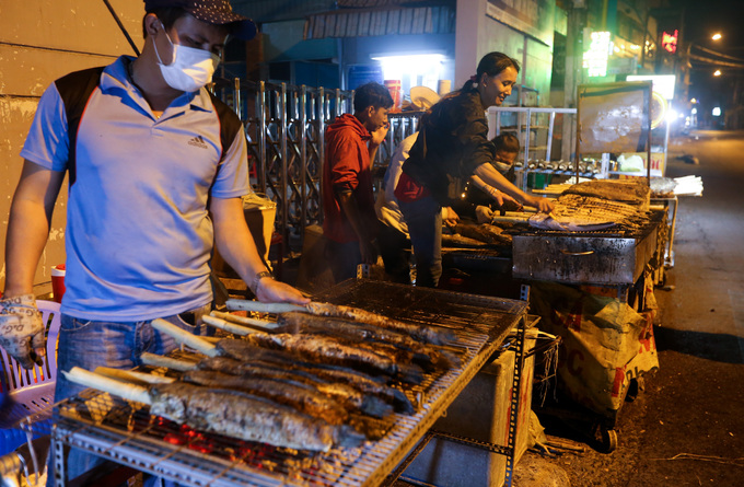 Hàng chục tiệm bán cá lóc nướng ở đây đều phải huy động thêm người làm. Mỗi người được phân công một nhiệm vụ như nhóm than, xiên cá, nướng, làm rau...