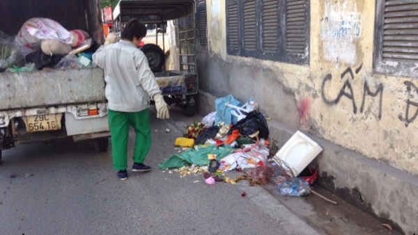 Công nhân môi trường phải căng mình ra tiến hành thu gom trên vỉa hè và ngay cả khu vực phía dưới lòng đường. Đây là một trong những nguy cơ tiềm ẩn gây tai nạn rất cao.