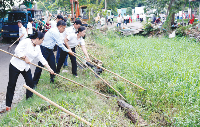 Phó Bí thư Thành ủy TP.HCM Võ Thị Dung (bìa trái) và Chủ tịch HND TP.HCM Nguyễn Thị Bạch Mai (bìa phải) cùng nông dân vệ sinh môi trường nông thôn.