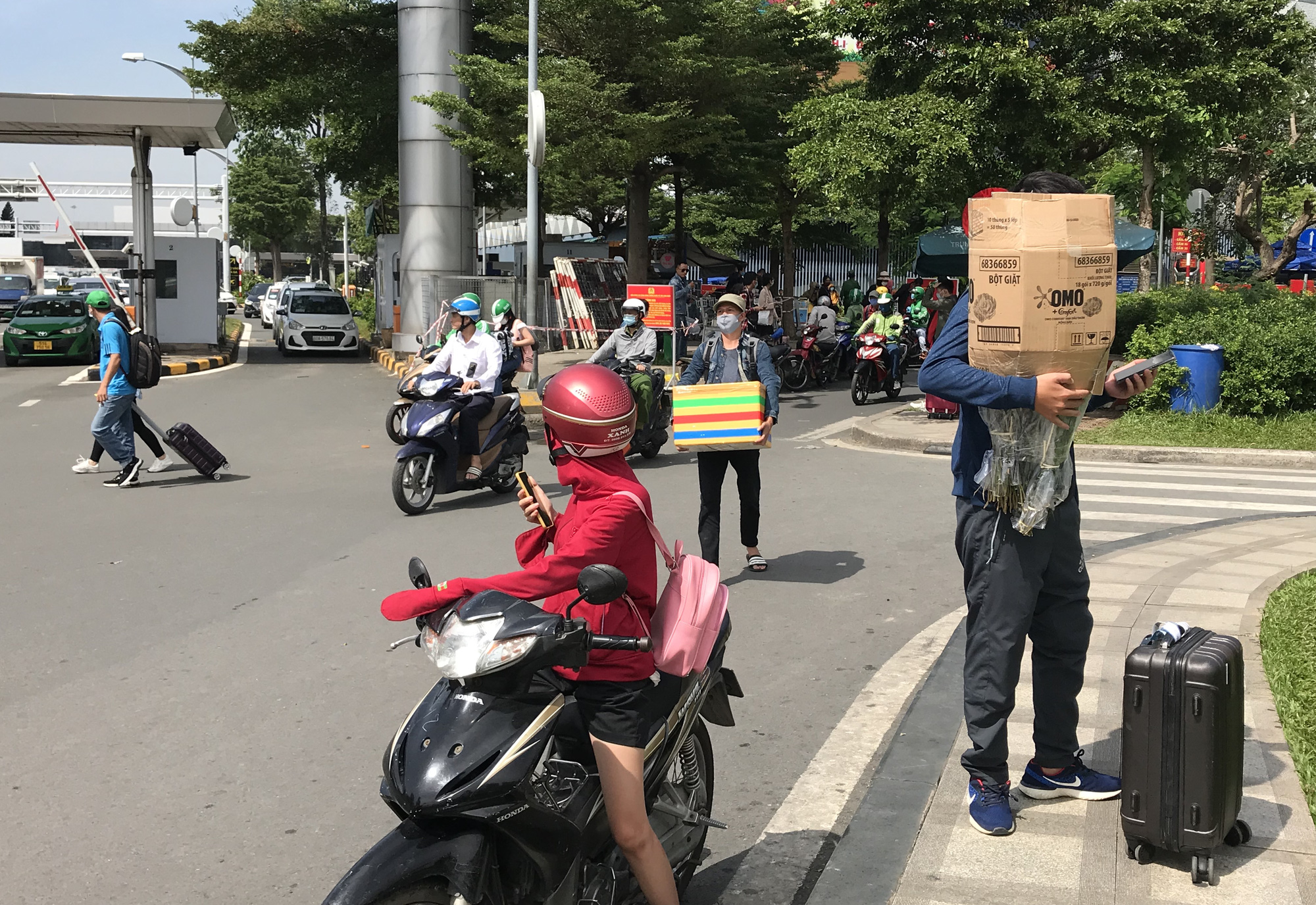 Khách vã mồ hôi, vác vali ra khỏi sân bay Tân Sơn Nhất,  cắt ngang làn ô tô để đón xe - Ảnh 2.