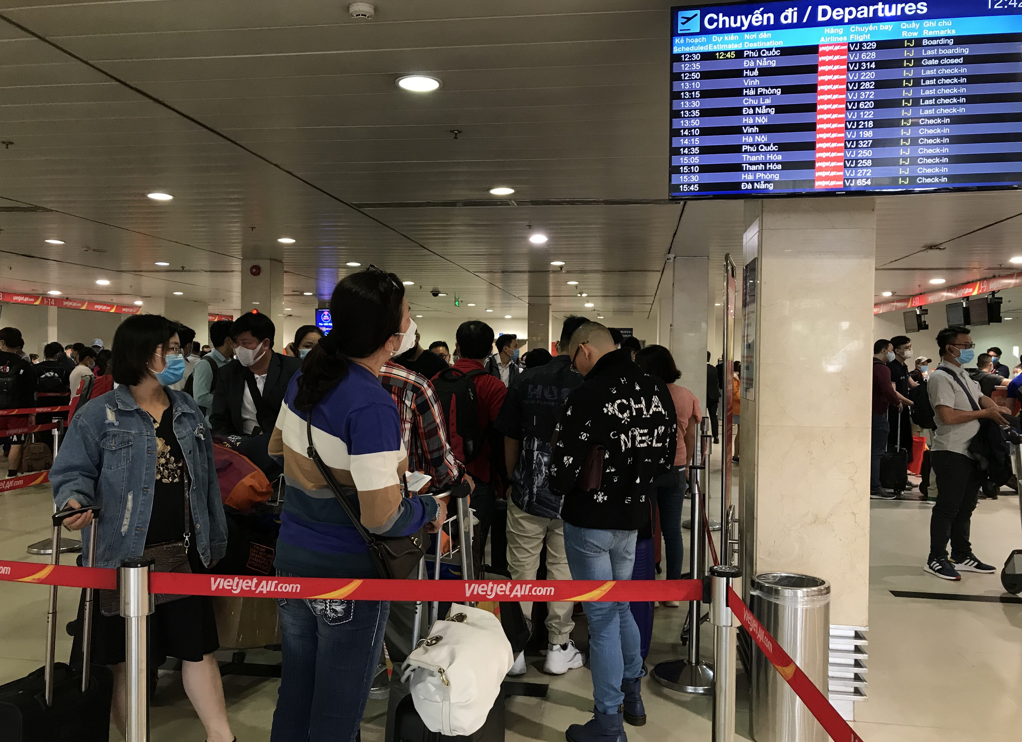 Người dân bắt đầu đổ về quê, sân bay Tân Sơn Nhất đông nghẹt, xếp hàng hơn nửa tiếng chờ check-in - Ảnh 8.