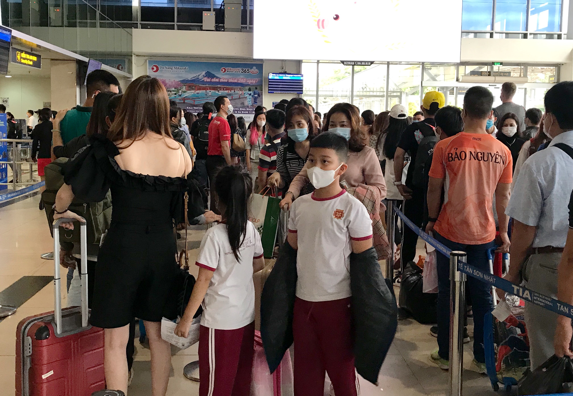 Người dân bắt đầu đổ về quê, sân bay Tân Sơn Nhất đông nghẹt, xếp hàng hơn nửa tiếng chờ check-in - Ảnh 7.