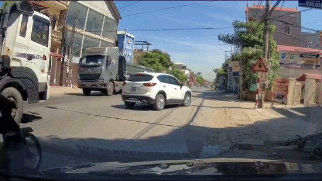 Video: Tông mạnh vào đuôi ô tô, thanh niên ngã kinh hoàng lúc xe tải chạy qua - Ảnh 1.