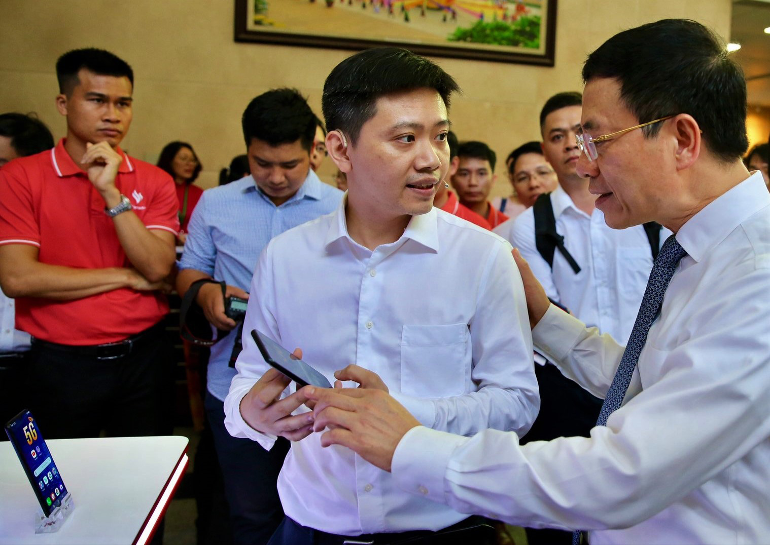 Bộ trưởng Bộ Thông tin và Truyền thông Nguyễn Mạnh Hùng trò chuyện với đại diện VinSmart về chiếc smartphone 5G đầu tiên. Ảnh: Bảo Chi