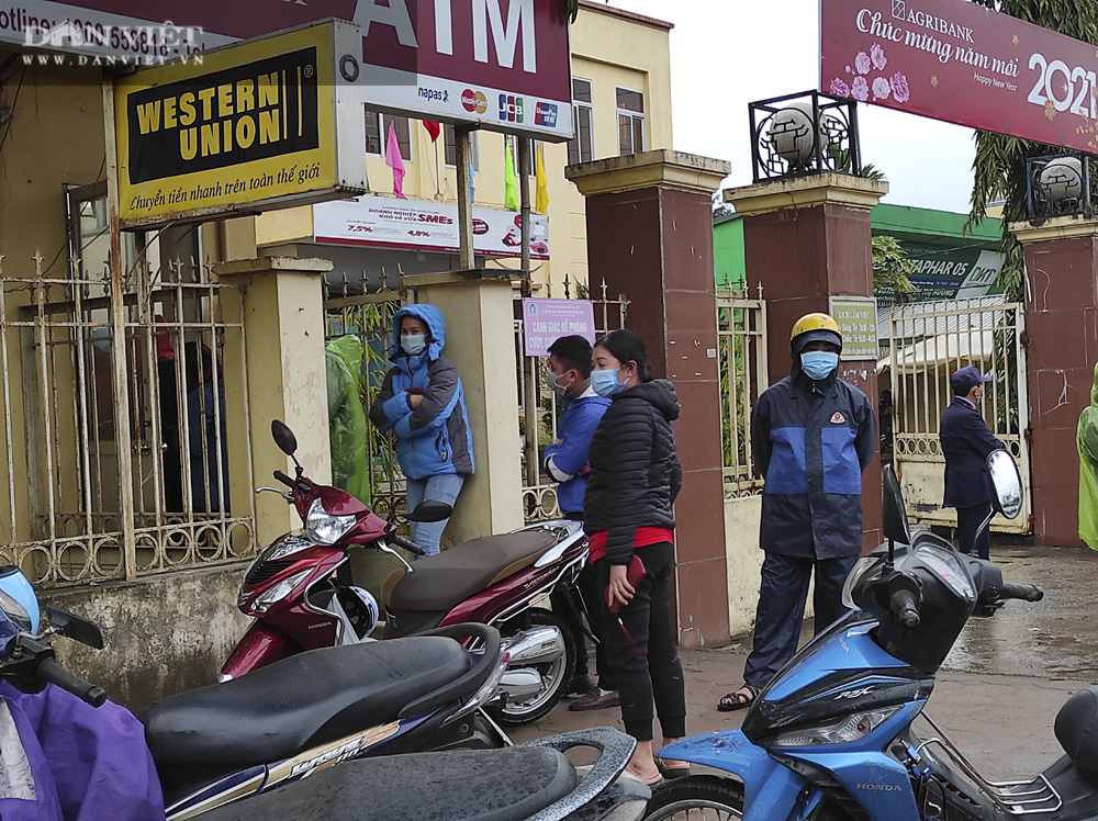 Công nhân đội mưa, xếp hàng dài rút tiền ở cây ATM ngày cận Tết Nguyên đán 2021 - Ảnh 11.