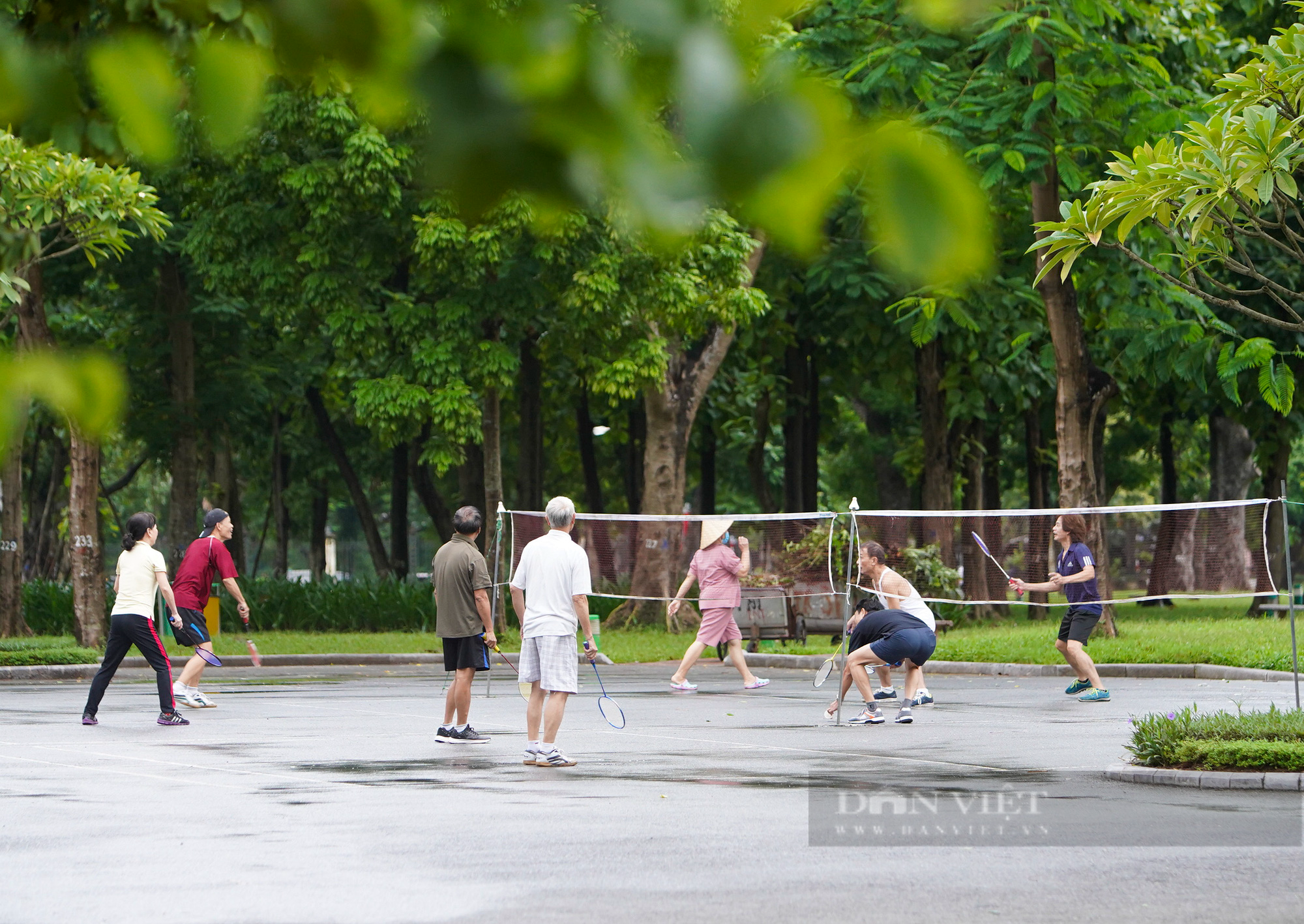 Hà Nội: Bất chấp mưa phùn, gió bấc, người dân mặc áo mưa ra công viên tập thể dục ngày đầu được mở lại - Ảnh 1.