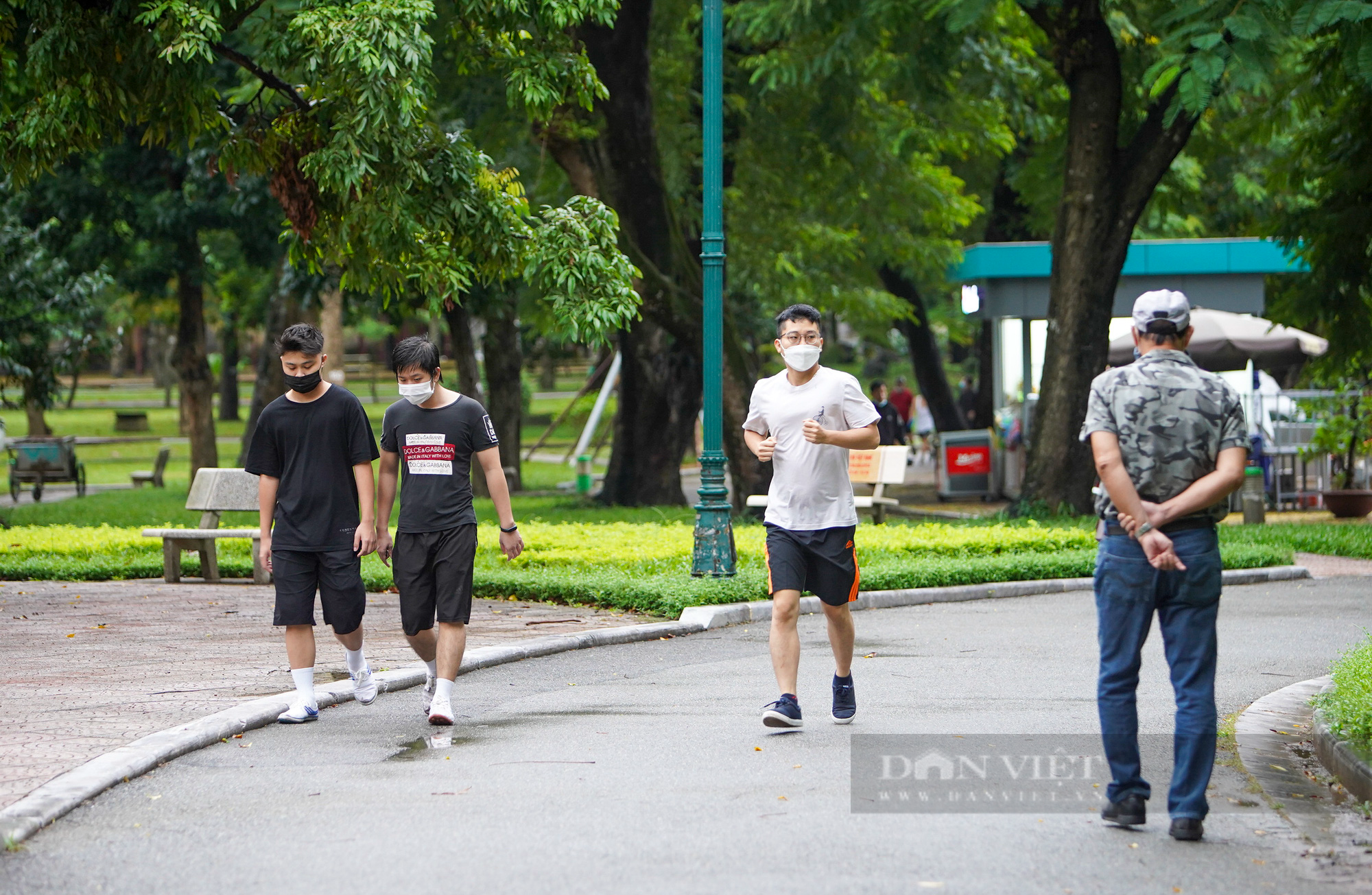 Hà Nội: Bất chấp mưa phùn, gió bấc, người dân mặc áo mưa ra công viên tập thể dục ngày đầu được mở lại - Ảnh 2.