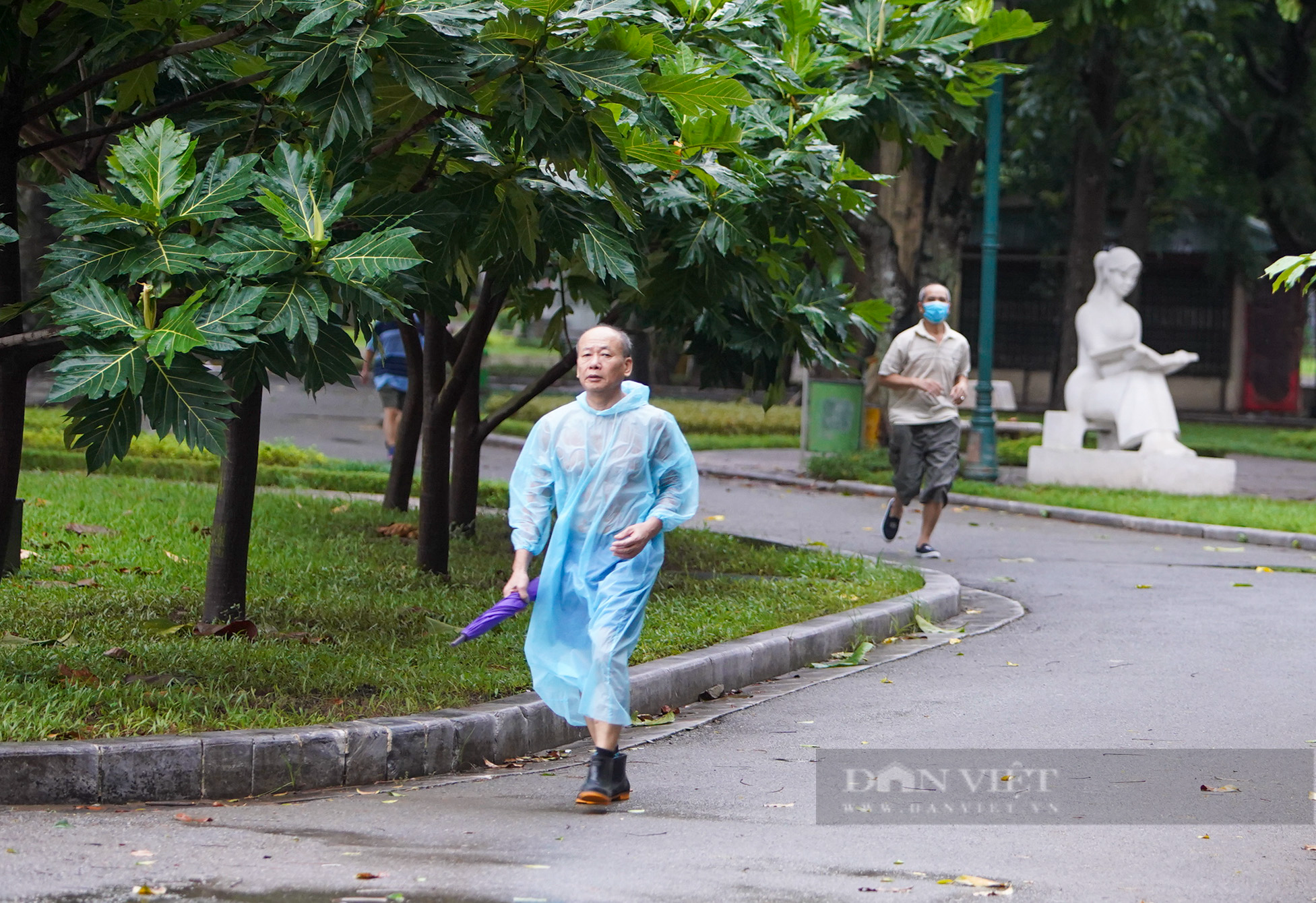 Hà Nội: Bất chấp mưa phùn, gió bấc, người dân mặc áo mưa ra công viên tập thể dục ngày đầu được mở lại - Ảnh 5.