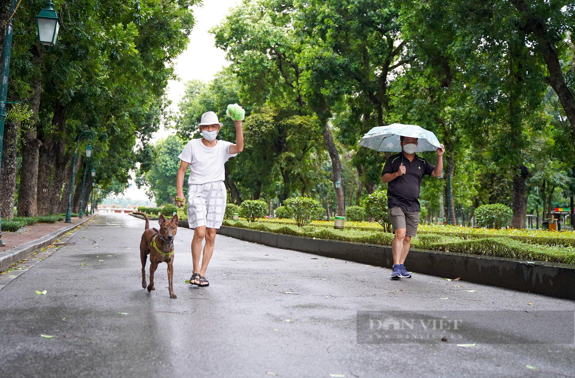 Hà Nội: Bất chấp mưa phùn, gió bấc, người dân mặc áo mưa ra công viên tập thể dục ngày đầu được mở lại - Ảnh 7.