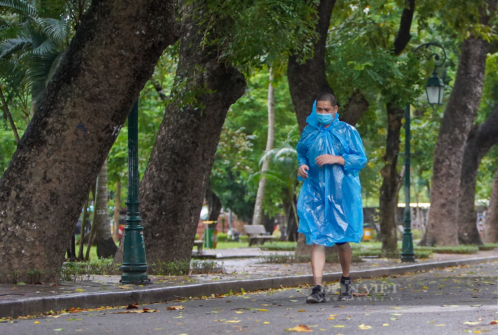 Hà Nội: Bất chấp mưa phùn, gió bấc, người dân mặc áo mưa ra công viên tập thể dục ngày đầu được mở lại - Ảnh 4.