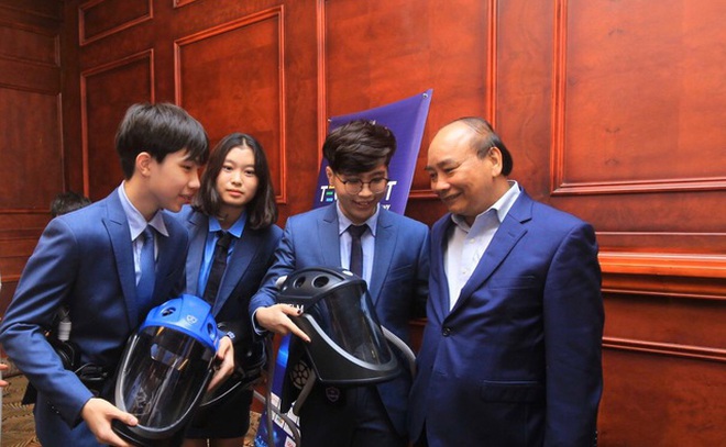 Chủ tịch nước Nguyễn Xuân Phúc và nhóm sáng chế trẻ của sản phẩm &quot;Mũ cách ly di động Vihelm&quot;.