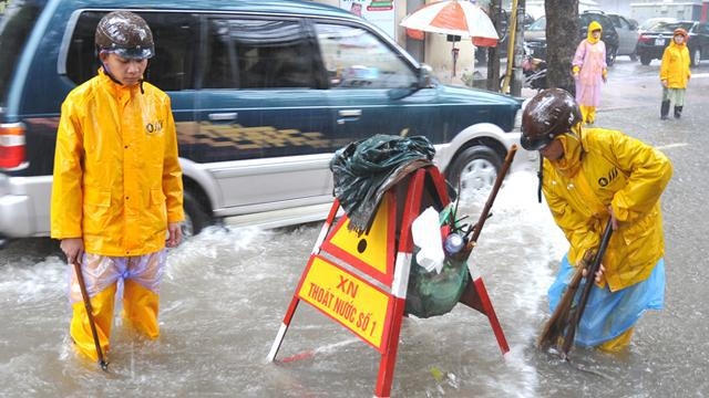 Công nhân Xí nghiệp thoát nước số 1, Công ty thoát nước Hà Nội ứng trực, xử lý ngập úng, bảo đảm giao thông trên phố Đội Cấn, quận Ba Đình (Hà Nội).