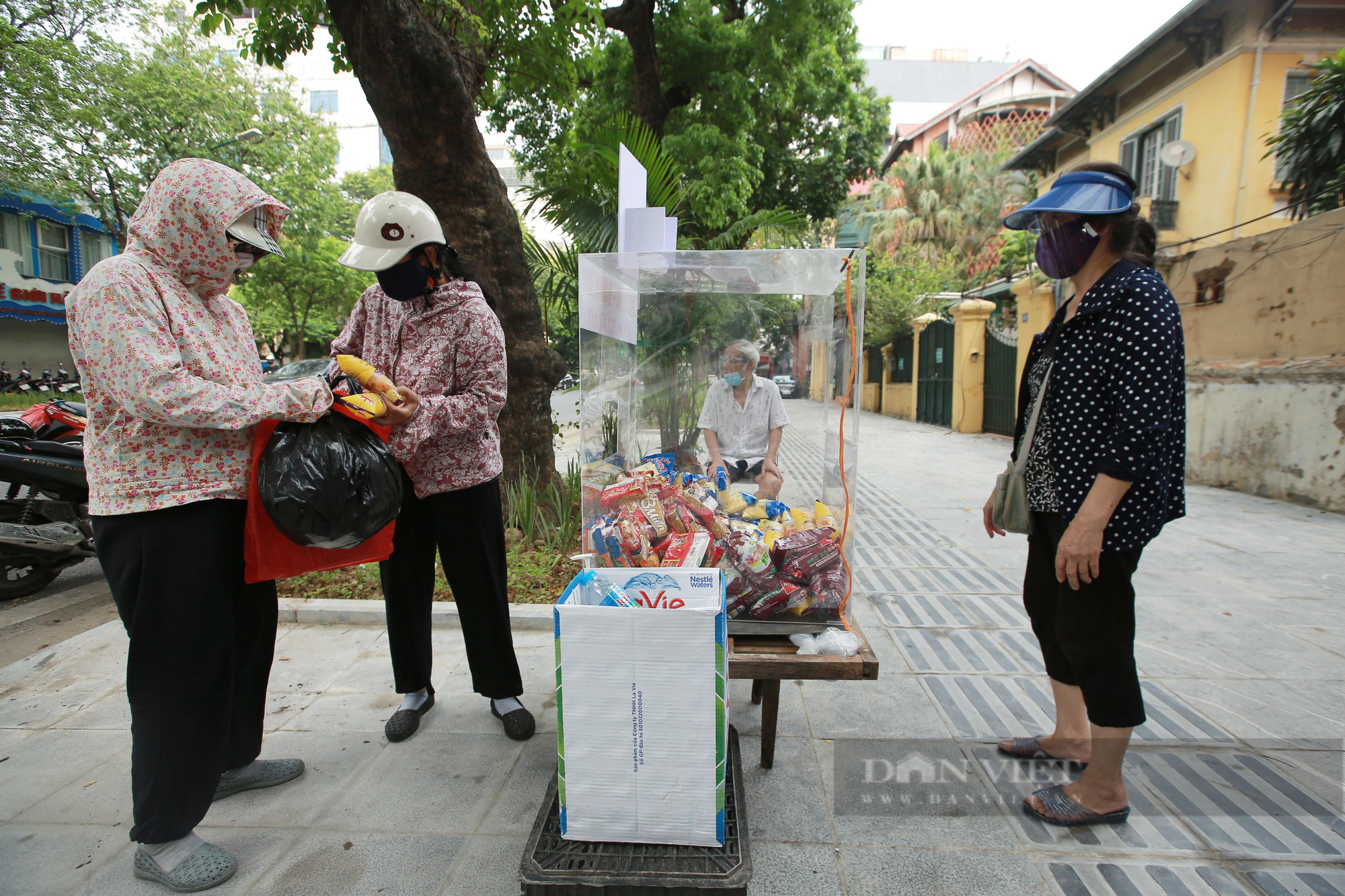 Ấm lòng tủ mì tôm, nước lọc miễn phí cho người khó khăn bên hè phố Hà Nội - Ảnh 2.