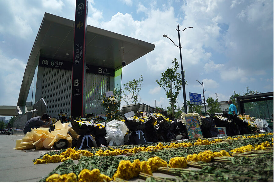 Những bó hoa được đặt bên ngoài ga tàu điện ngầm ở Trịnh Châu, Trung Quốc vào ngày 27/7/2021. Người dân đã đặt hoa ở lối vào ga tàu điện ngầm, nơi có nhiều người chết sau trận mưa lớn kỷ lục làm ngập thành phố. Ảnh: @AP.