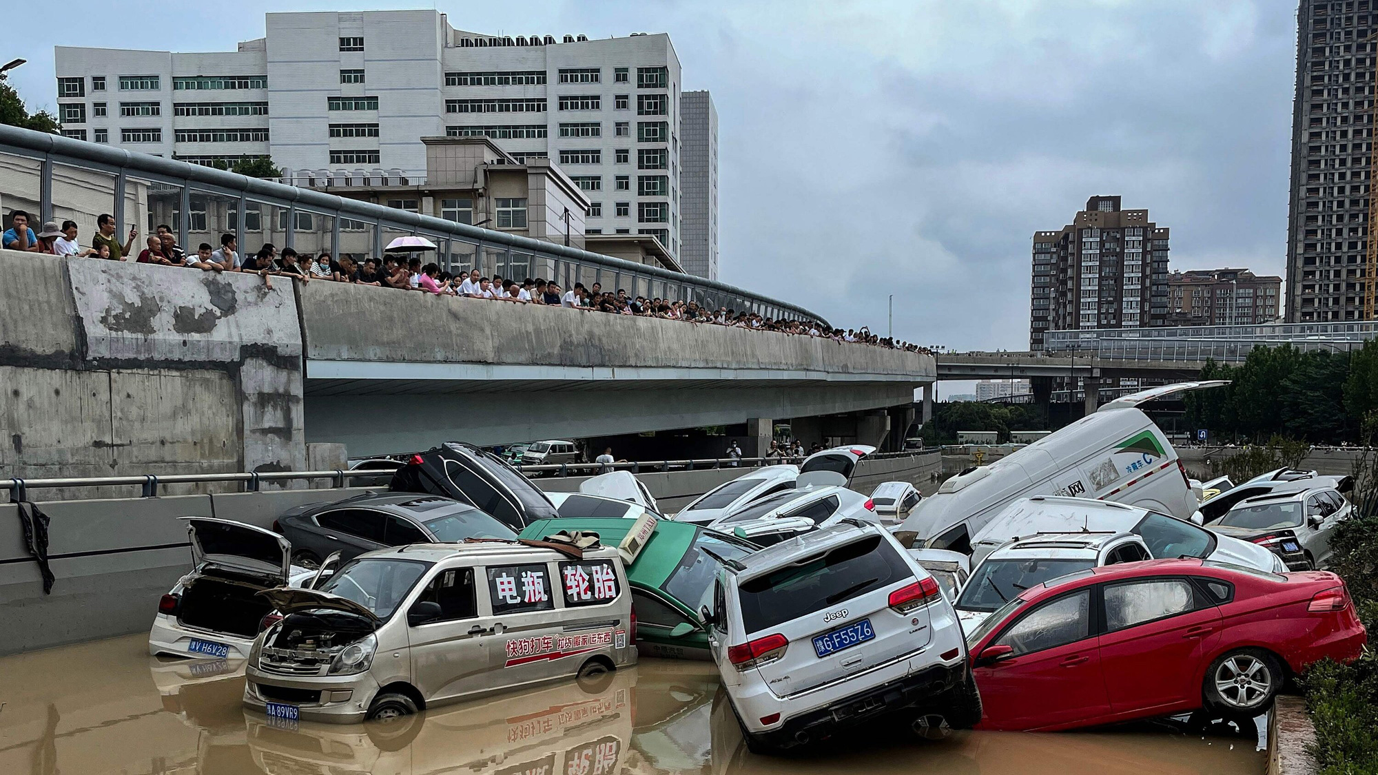 Hình ảnh kinh hoàng về những chiếc ô tô bị lật và những người bị mắc kẹt trong tàu điện ngầm và đường phố ngập lụt ở Trung Quốc đã tràn ngập trên mạng xã hội trong những ngày qua. Ảnh: @AP.