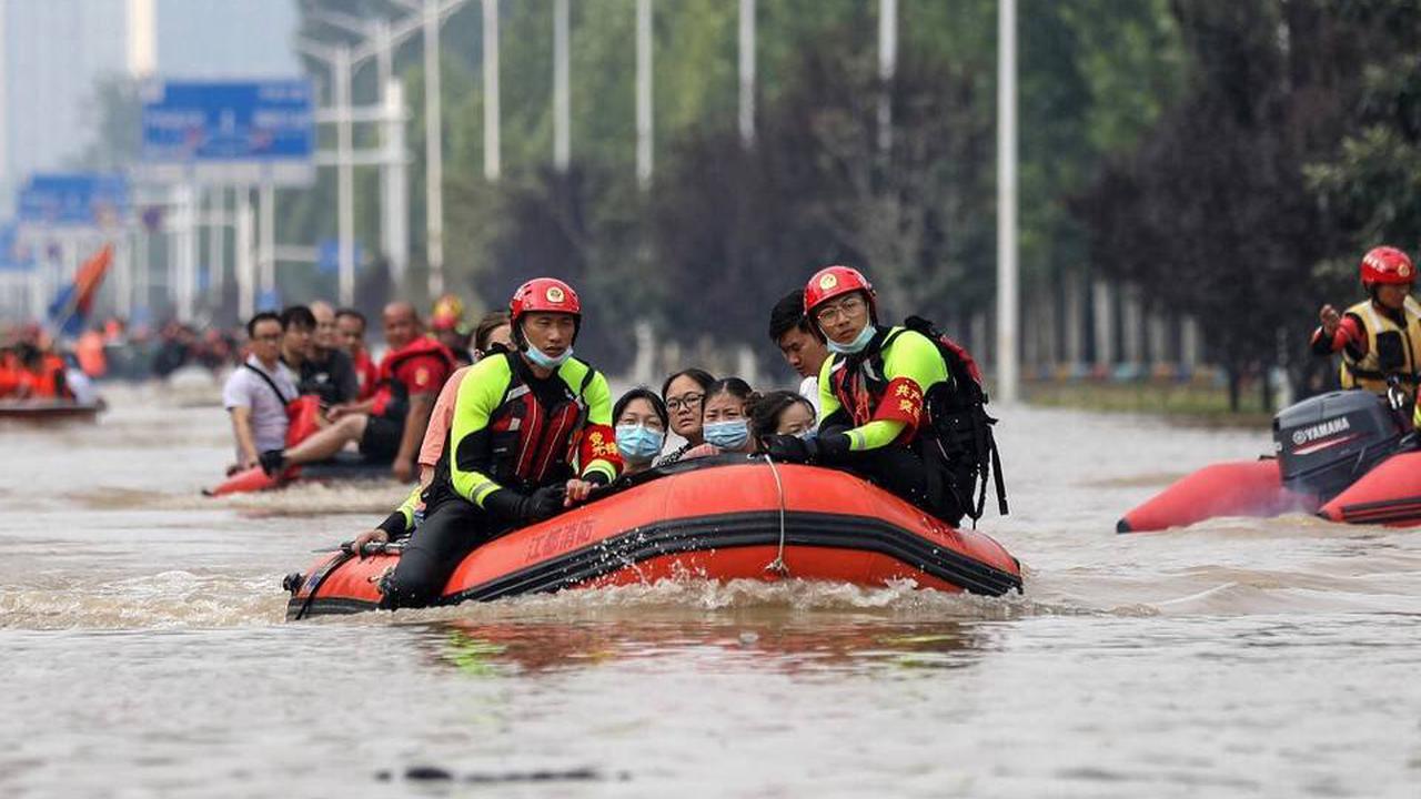 Các nhân viên cứu hộ chèo thuyền qua một con phố ngập lụt ở Trịnh Châu, Trung Quốc, ngày 23/7. Ảnh: @AP.