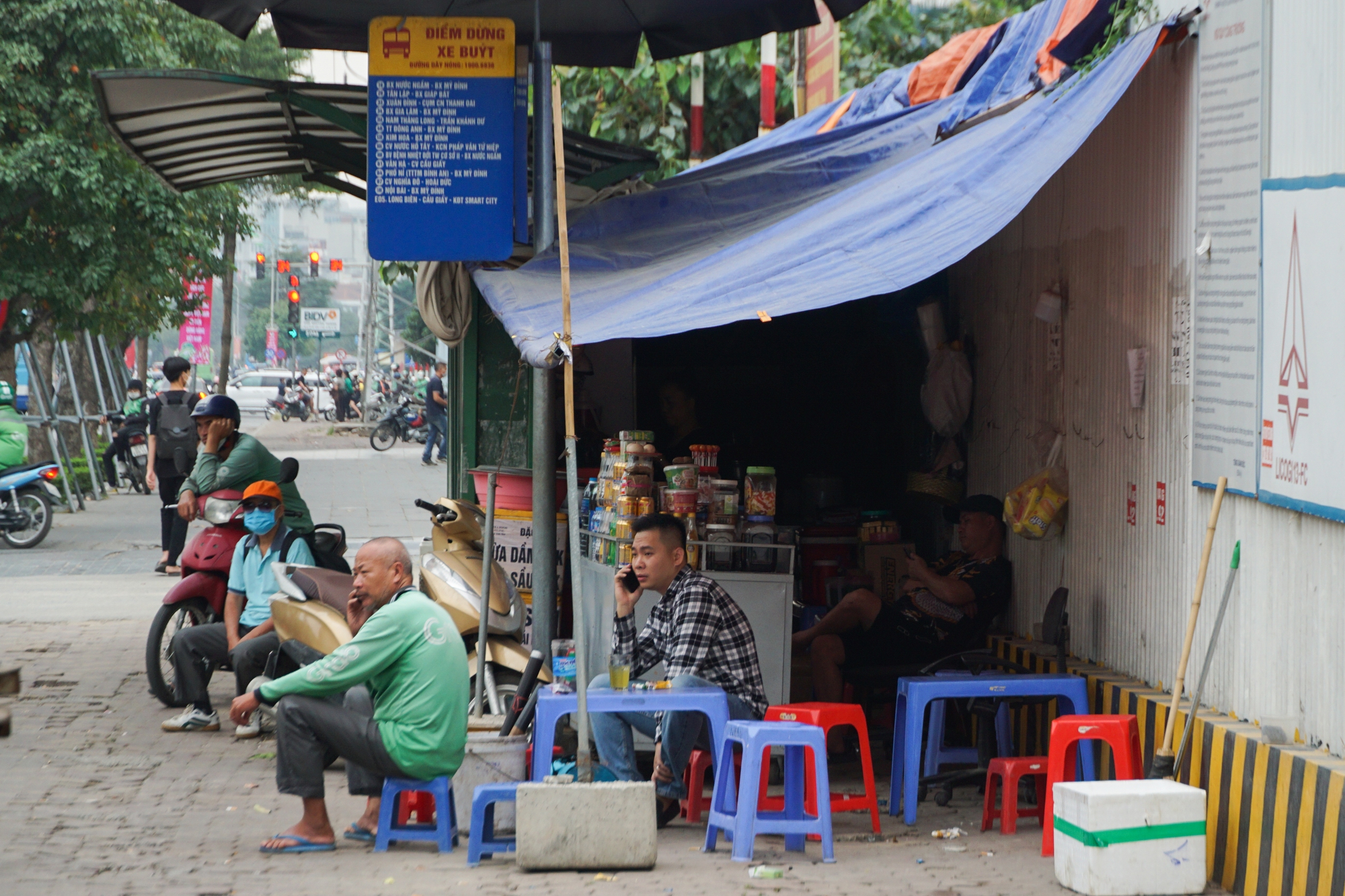 Các nhà chờ xe buýt ở Hà Nội bị &quot;hô biến&quot; thành hàng quán, rác thải bủa vây - Ảnh 14.