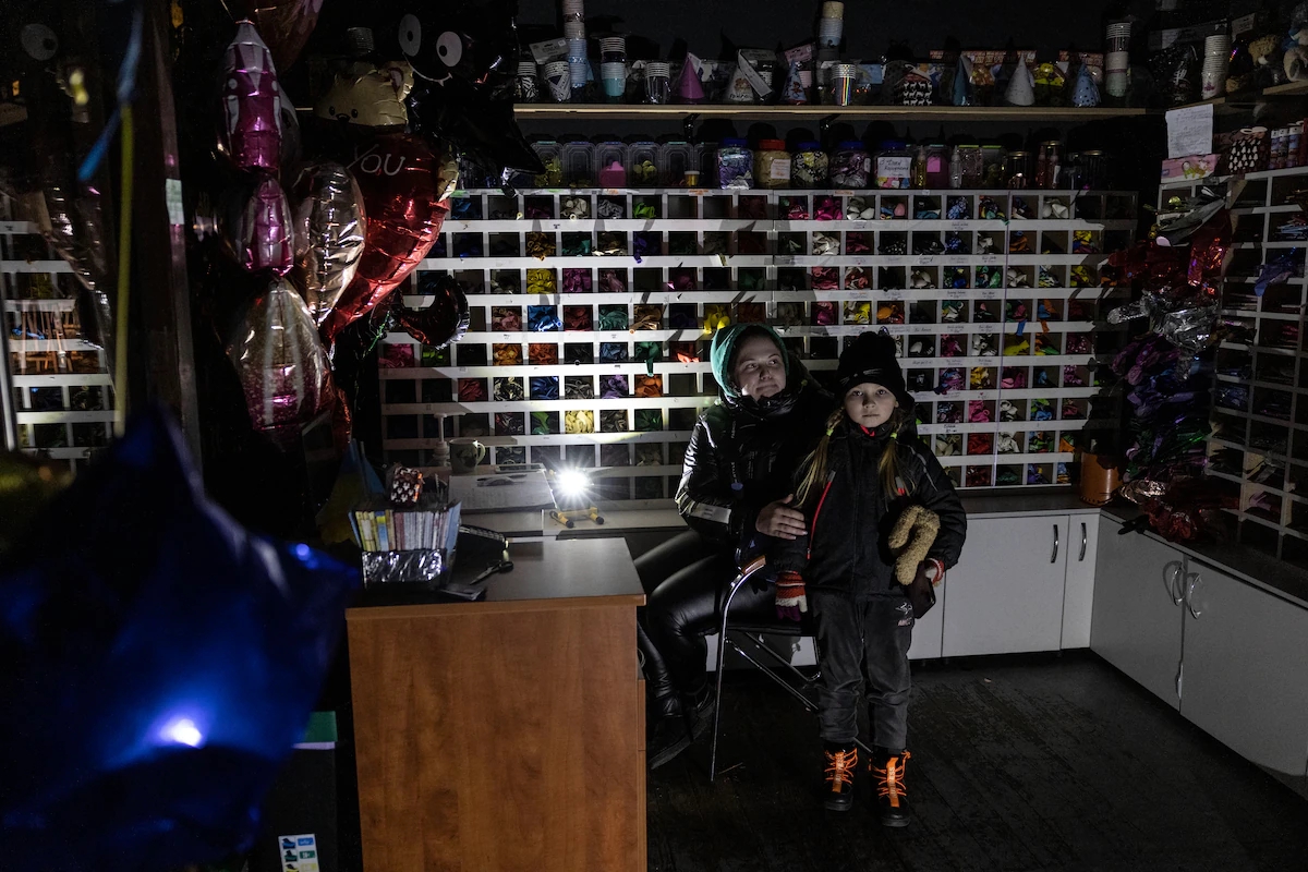 Liudmyla Tsybulska, 26 tuổi, và con gái Zlata, 5 tuổi, tại cửa hàng khinh khí cầu, họ đang đợi khách hàng trong thời gian mất điện ở Dnipro, Ukraine, vào ngày 29 tháng 11. Ảnh: @Heidi Levine/ The Washington Post.
