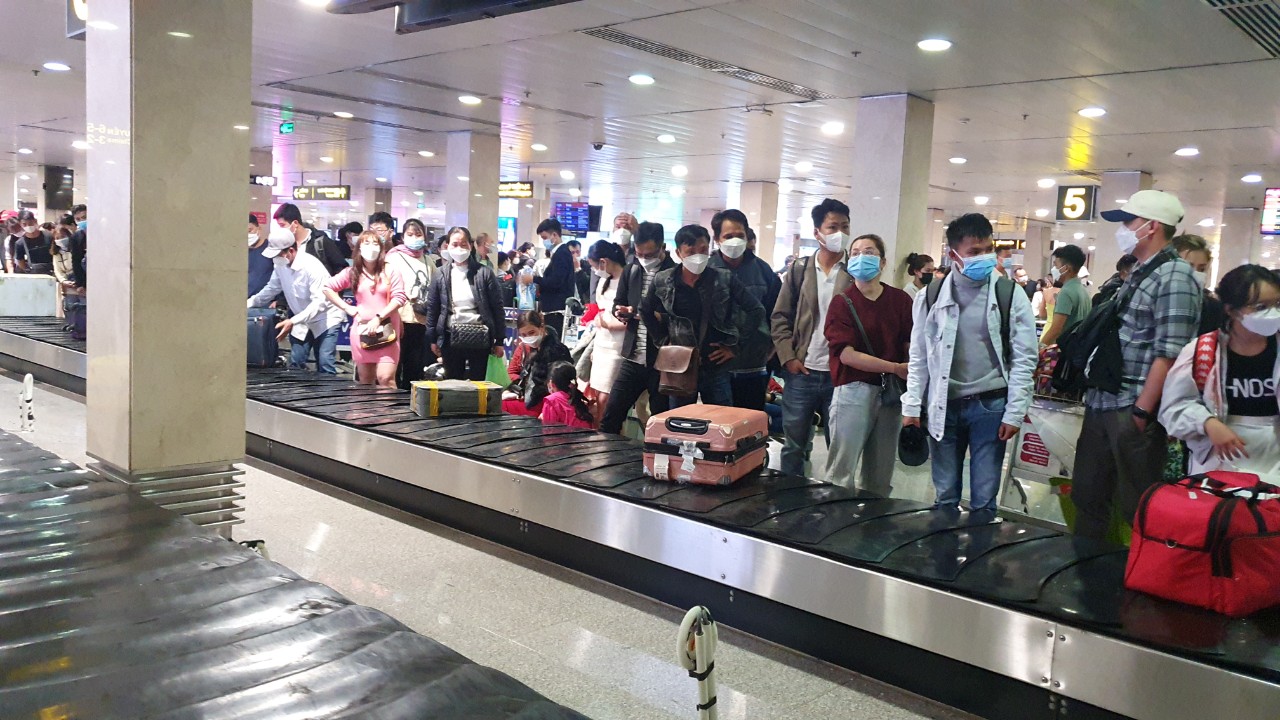 Hành khách vạ vật ở sân bay Tân Sơn Nhất rạng sáng 7-2 chờ lấy hành lý, gọi xe - Ảnh 6.
