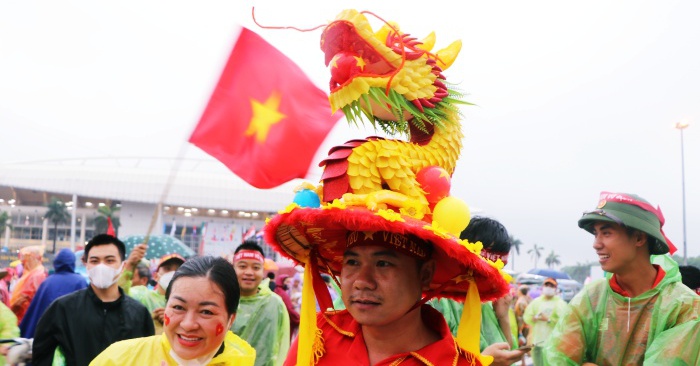 Fans wearing dragon hats cheered in the heavy rain to “refuel” U23 Vietnam