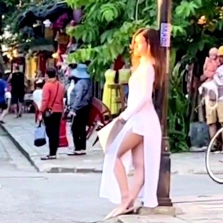 Wearing shorts and ao dai taking pictures in Hoi An ancient town, two young girls were 