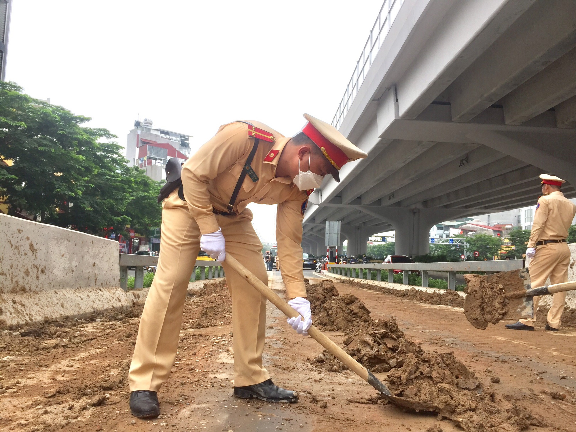 Bùn đất chất đầy lối vào đường vành đai 3, CSGT Hà Nội xúc đất, dọn đường - Ảnh 2.